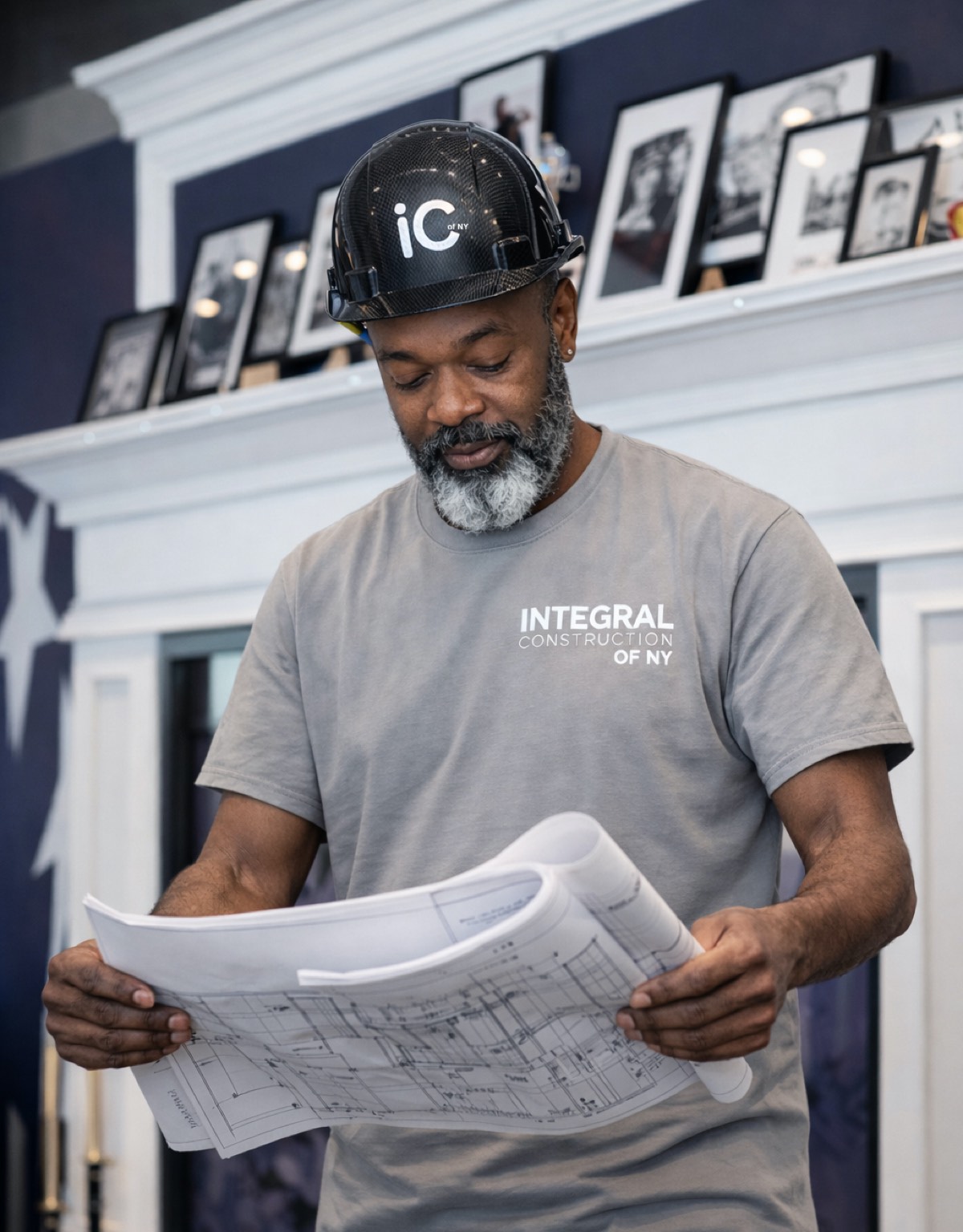 A member of the Integral team in an Integral hard hat, reading the drawing set on site